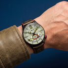 Wrist shot of AVI-8 Peanuts Snoopy watch with sand dial and olive green leather strap
